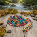 Colorful  agate beaded necklace with tassel on a wooden surface near a stream 
