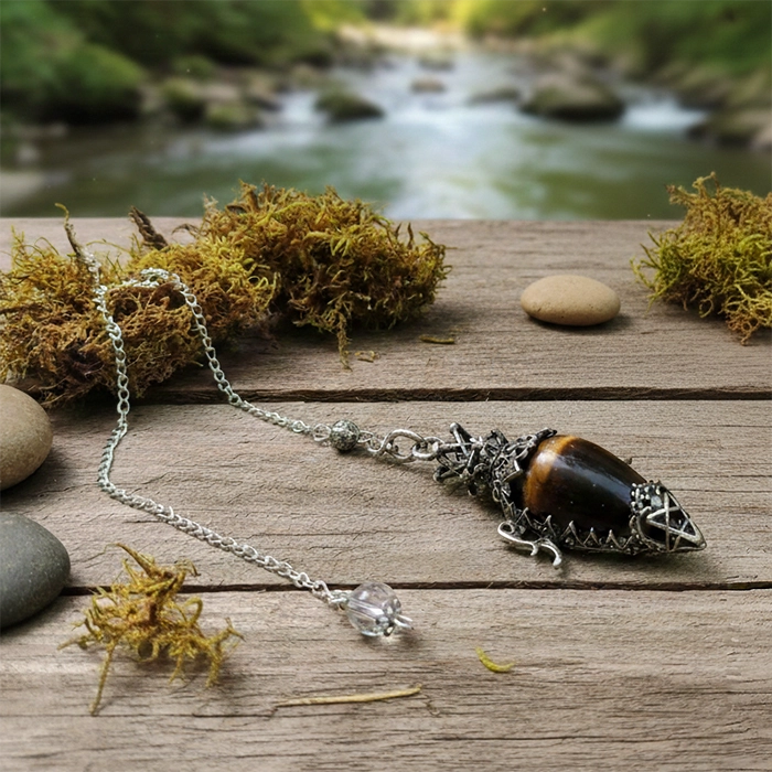 Dowsing pendant tigers eye ependant on a wooden surface with a natural background