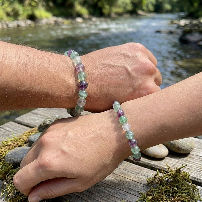 Pulseras de fluorita natural en muñeca, cuentas verdes y moradas en exterior | AuryStone